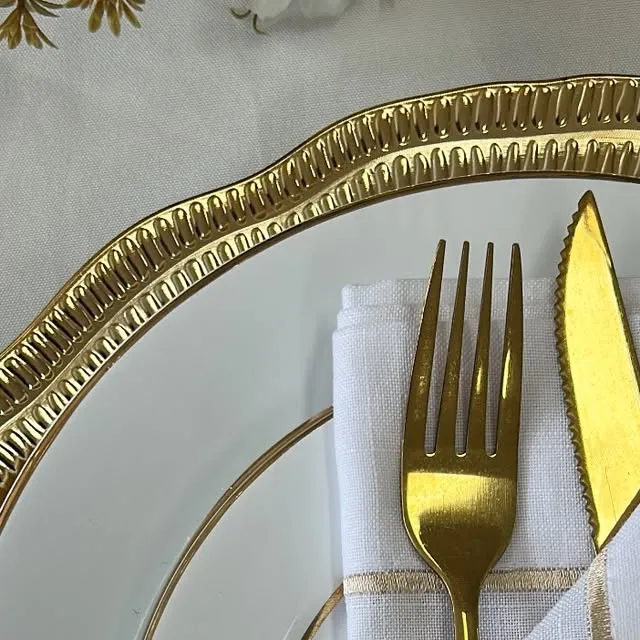 Close de mesa posta com sousplat dourado e talheres