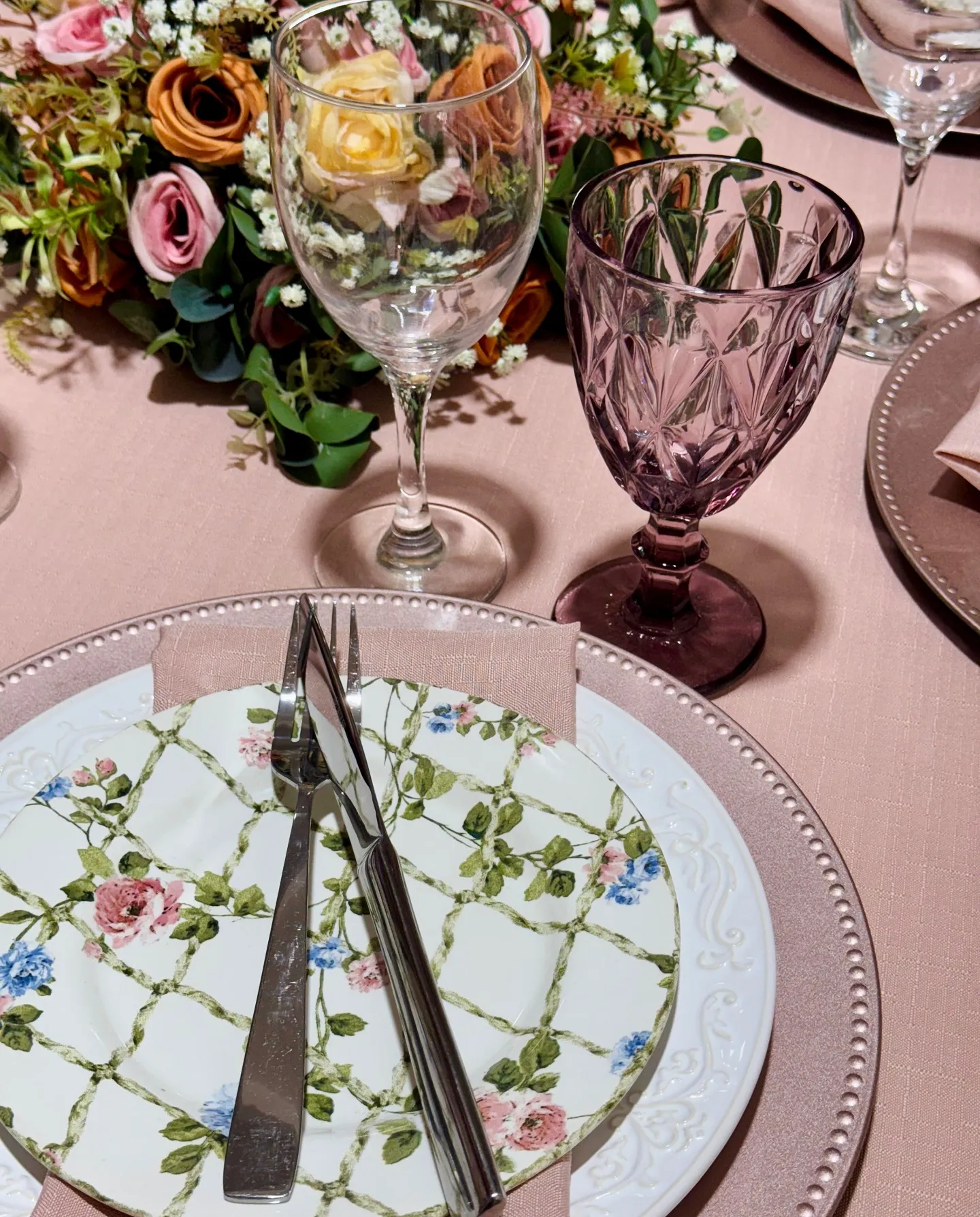 Close de mesa posta rosa com pratos florais