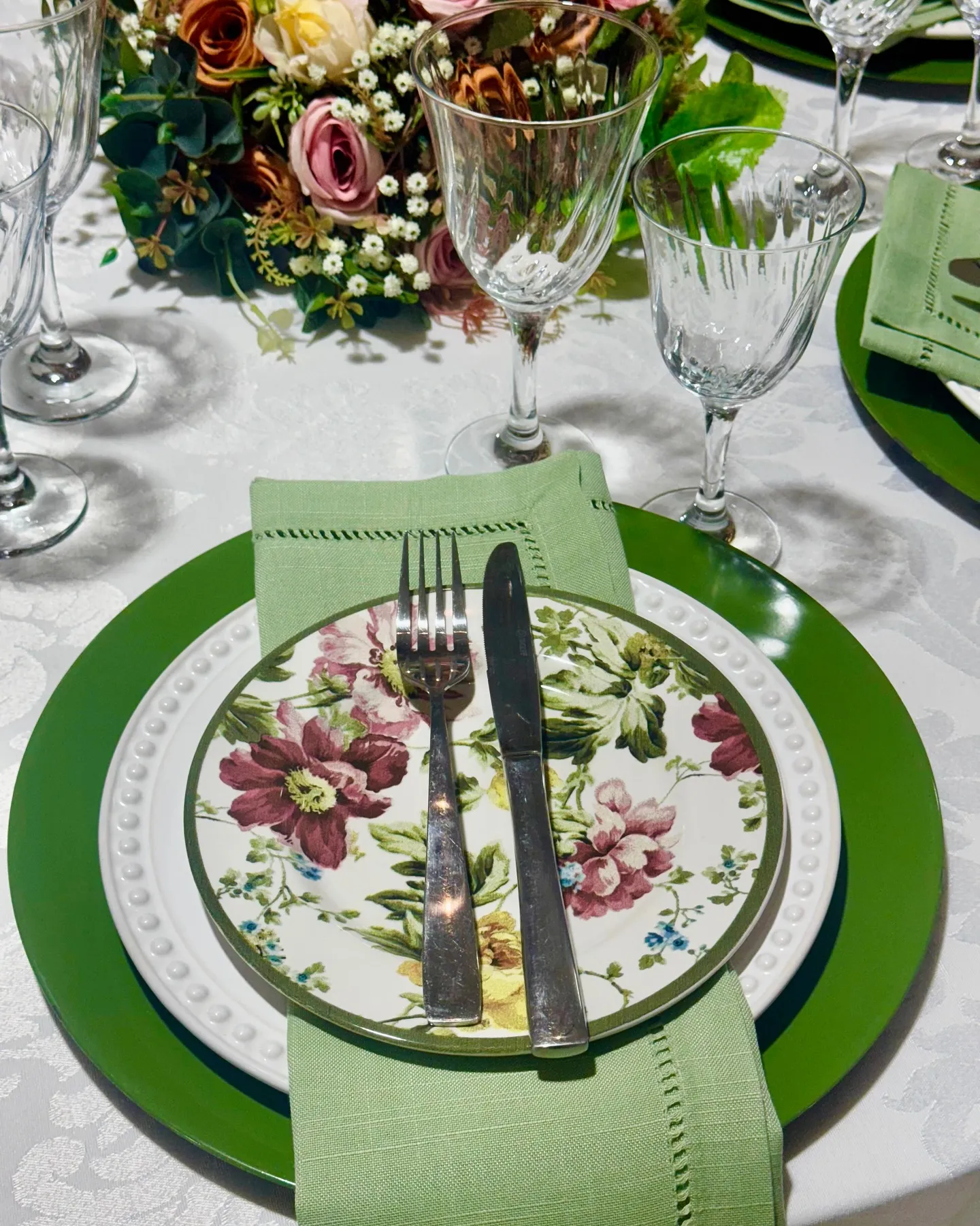 Mesa posta em tons verdes com pratos florais