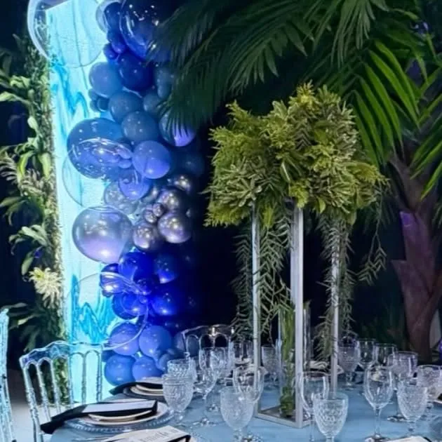Decoração corporativa em azul com balões e vegetação